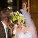kissing behind flower bouquet wedding photo