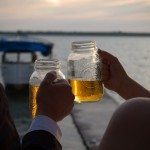 bride groom cheer beer sunset on lake photo