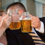wedding kiss behind beer mason jar photo