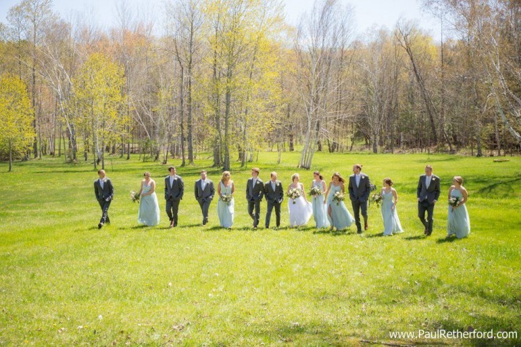 walking in a field wedding party