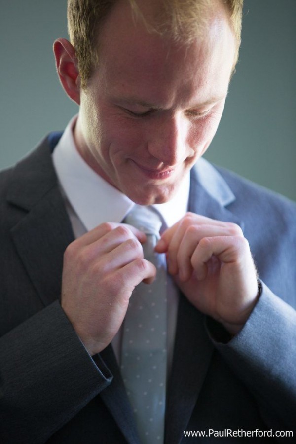 groom tying tie photo